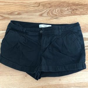 khaki material, black shorts